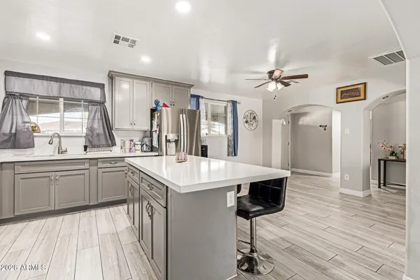 a kitchen with stainless steel appliances a kitchen island hardwood floor sink stove and wooden floor