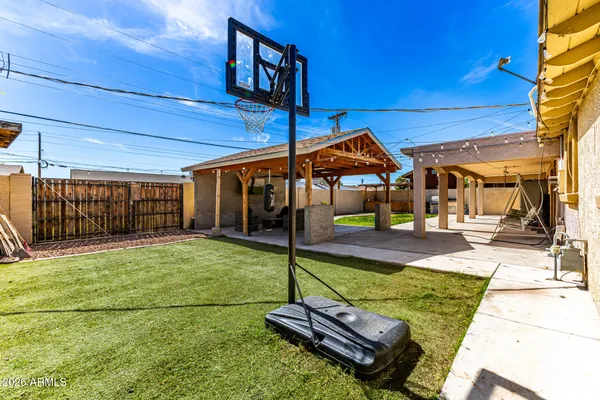 a view of a backyard with table and chairs under an umbrella