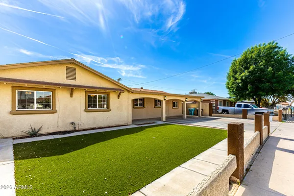 a front view of a house with a garden and yard