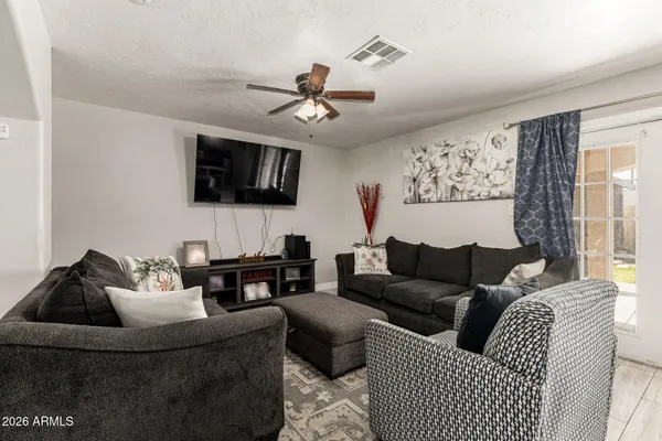 a living room with furniture a flat screen tv and a window