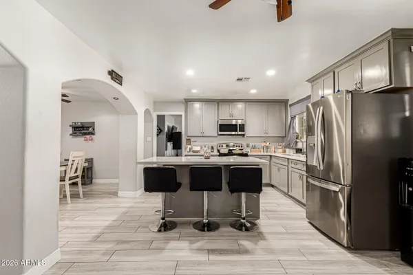 a kitchen with stainless steel appliances kitchen island granite countertop a refrigerator and a stove top oven