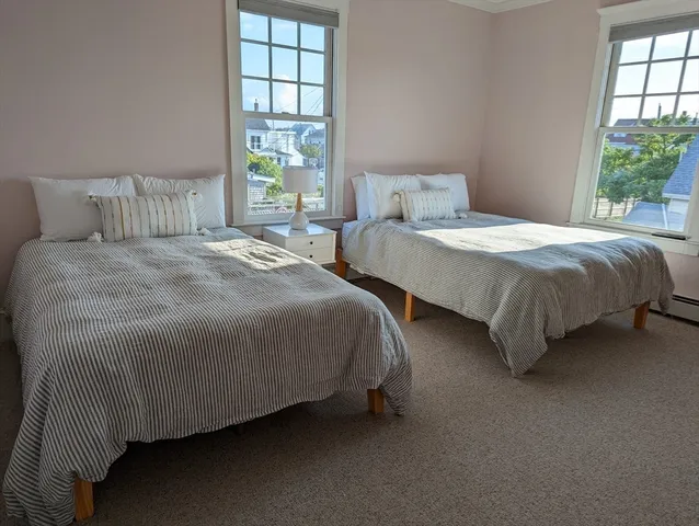 a bedroom with two beds and windows