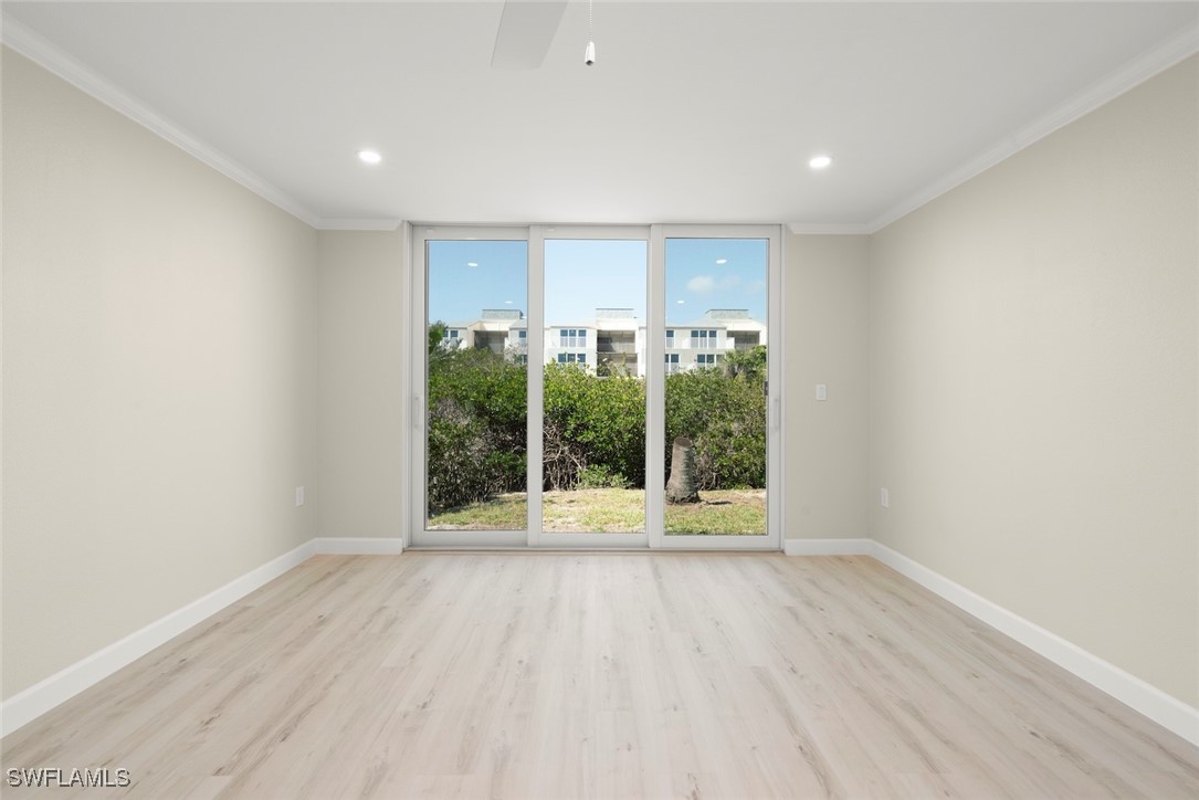 200 Periwinkle Way, Unit 132 Sanibel, FL 33957 - Photo 12 of 44 a view of an empty room with wooden floor and a window