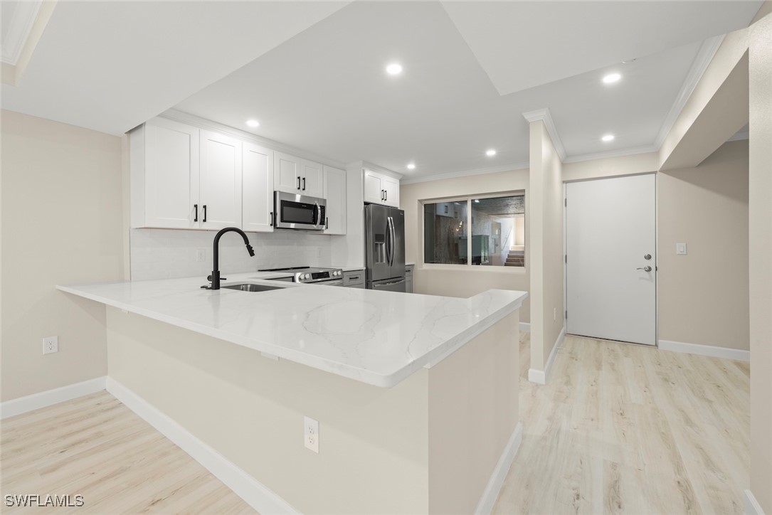 200 Periwinkle Way, Unit 132 Sanibel, FL 33957 - Photo 21 of 44 a view of a kitchen with a sink stainless steel appliances and cabinets