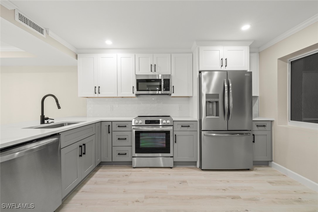 200 Periwinkle Way, Unit 132 Sanibel, FL 33957 - Photo 22 of 44 a kitchen with stainless steel appliances white cabinets a sink and a refrigerator