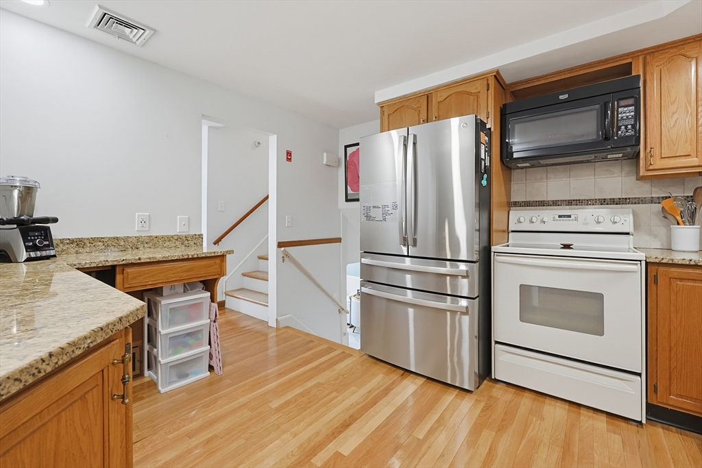 19 Weir Road Waltham, MA 02451 - Photo 3 of 41 a kitchen with stainless steel appliances wooden floor sink and wooden cabinets