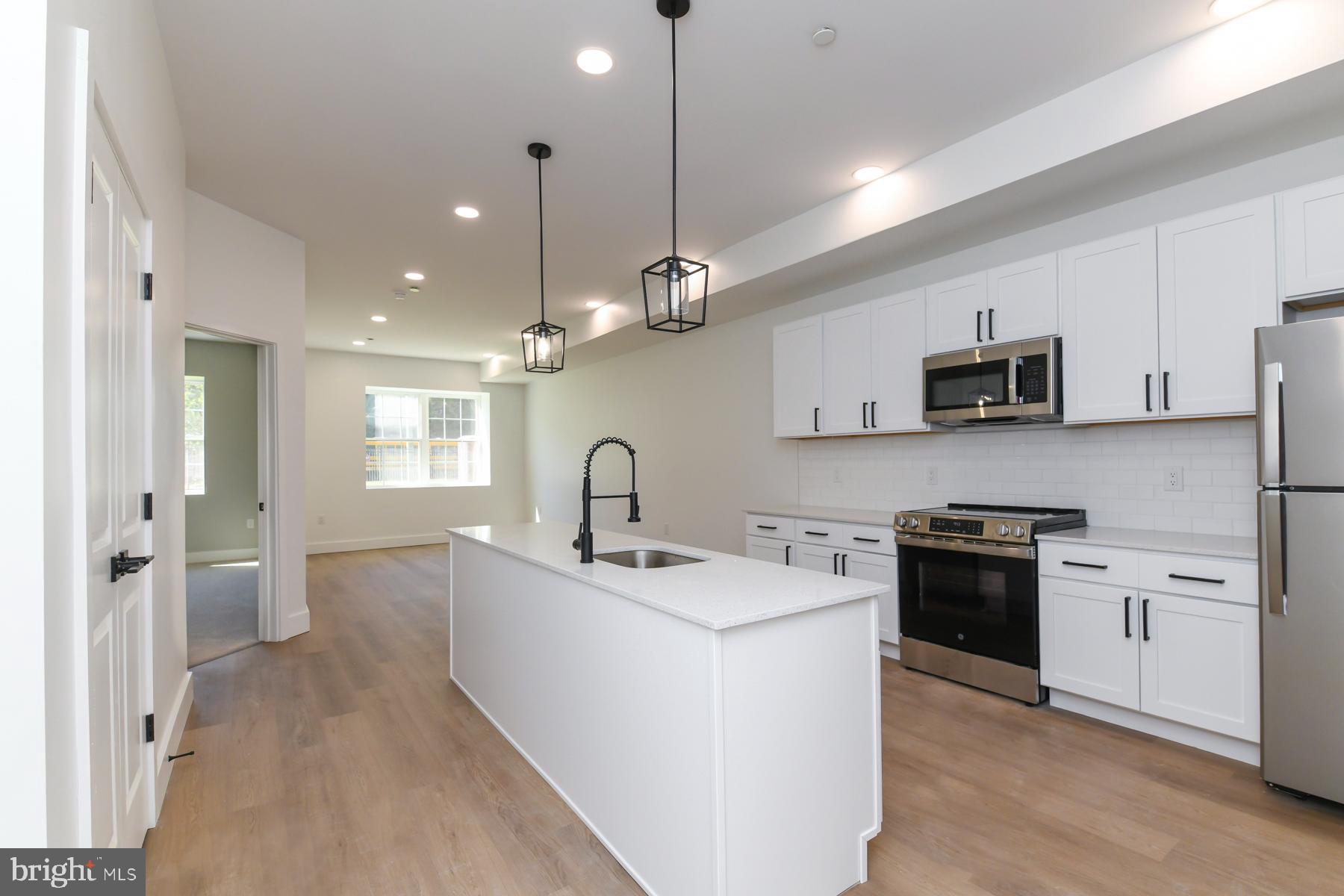 100 Aura Road, Unit 111 Clayton, NJ 08312 - Photo 19 of 34 a kitchen with stainless steel appliances granite countertop a sink a stove a refrigerator cabinets and a window