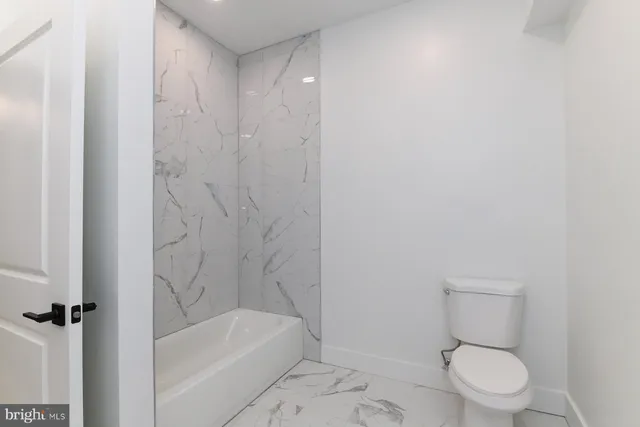 a kitchen with a sink a chandelier stainless steel appliances and cabinets