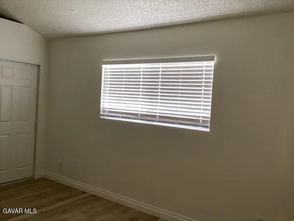 a view of a small space with wooden floor and a window