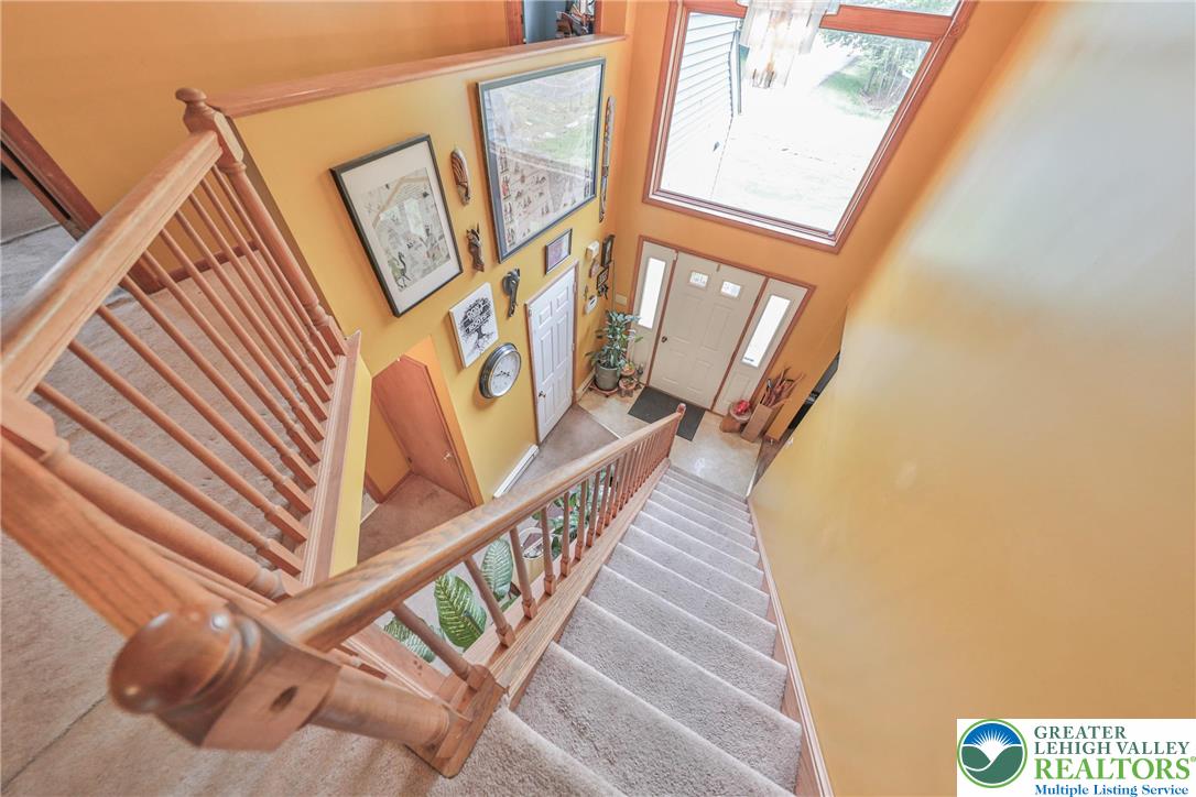 4608 Pine Ridge Drive West Bushkill, PA 18324 - Photo 46 of 62 Natural light streams into this welcoming entryway, highlighting the warm wood staircase and inviting landing.