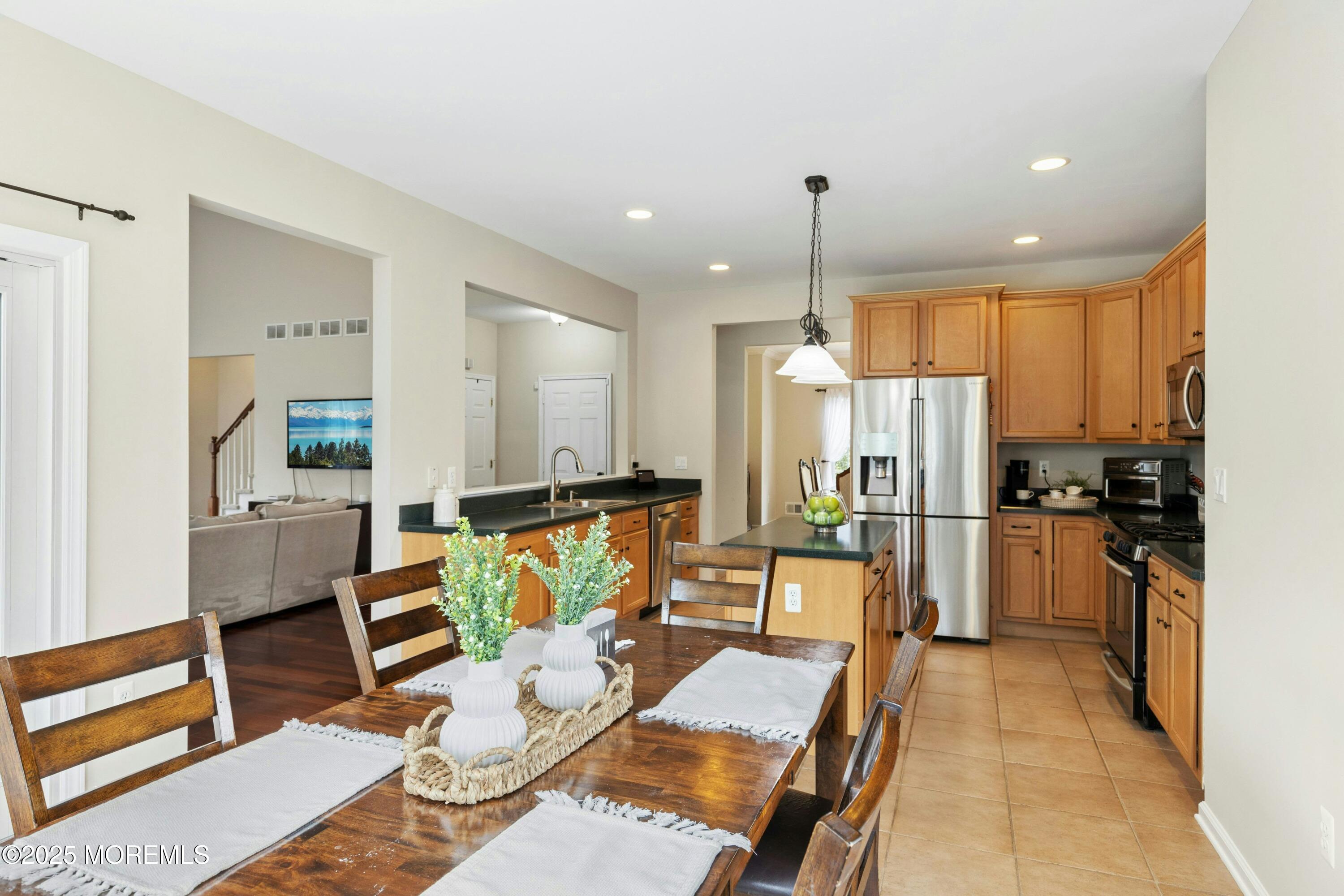 7 Topaz Drive Jackson, NJ 08527 - Photo 11 of 51 a kitchen with stainless steel appliances kitchen island granite countertop a refrigerator a stove a sink dishwasher with a dining table and chairs with wooden floor