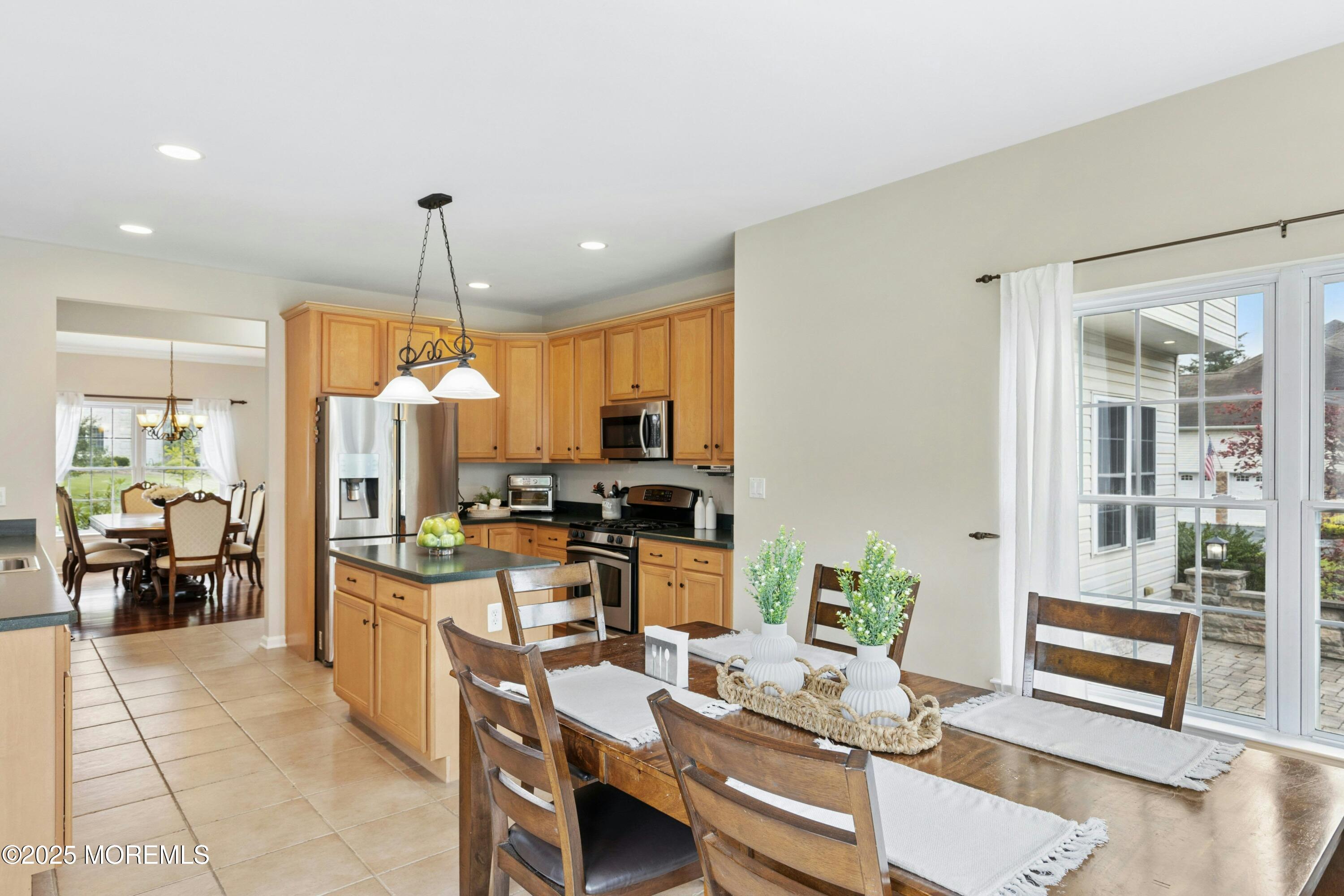 7 Topaz Drive Jackson, NJ 08527 - Photo 10 of 51 a kitchen with a refrigerator a stove and a dining table with wooden floor