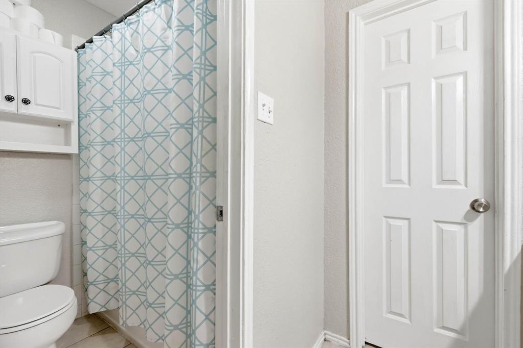 1312 Hackamore Street Mesquite, TX 75149 - Photo 15 of 23 Bathroom featuring a shower with curtain, a textured wall, and light tile patterned floors
