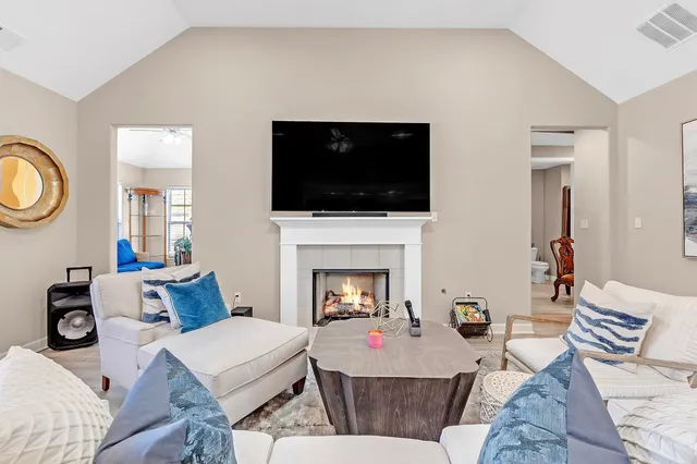 a large white kitchen with lots of counter space dining table and stainless steel appliances