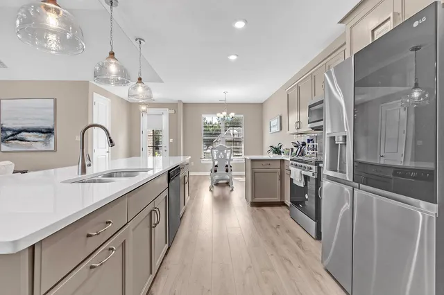 a kitchen with counter top space a sink appliances and cabinets