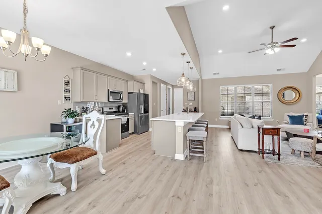 a large white kitchen with a table and chairs