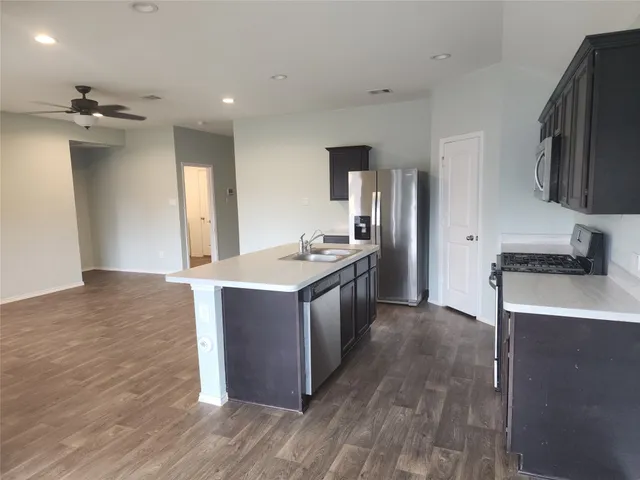 a kitchen with stainless steel appliances granite countertop a sink stove and refrigerator