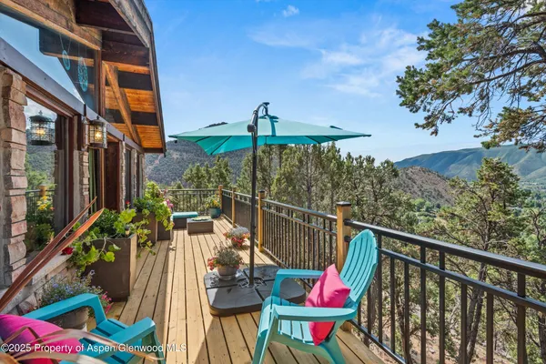 a kitchen with stainless steel appliances granite countertop a refrigerator a sink dishwasher a stove and a dining table with wooden floor
