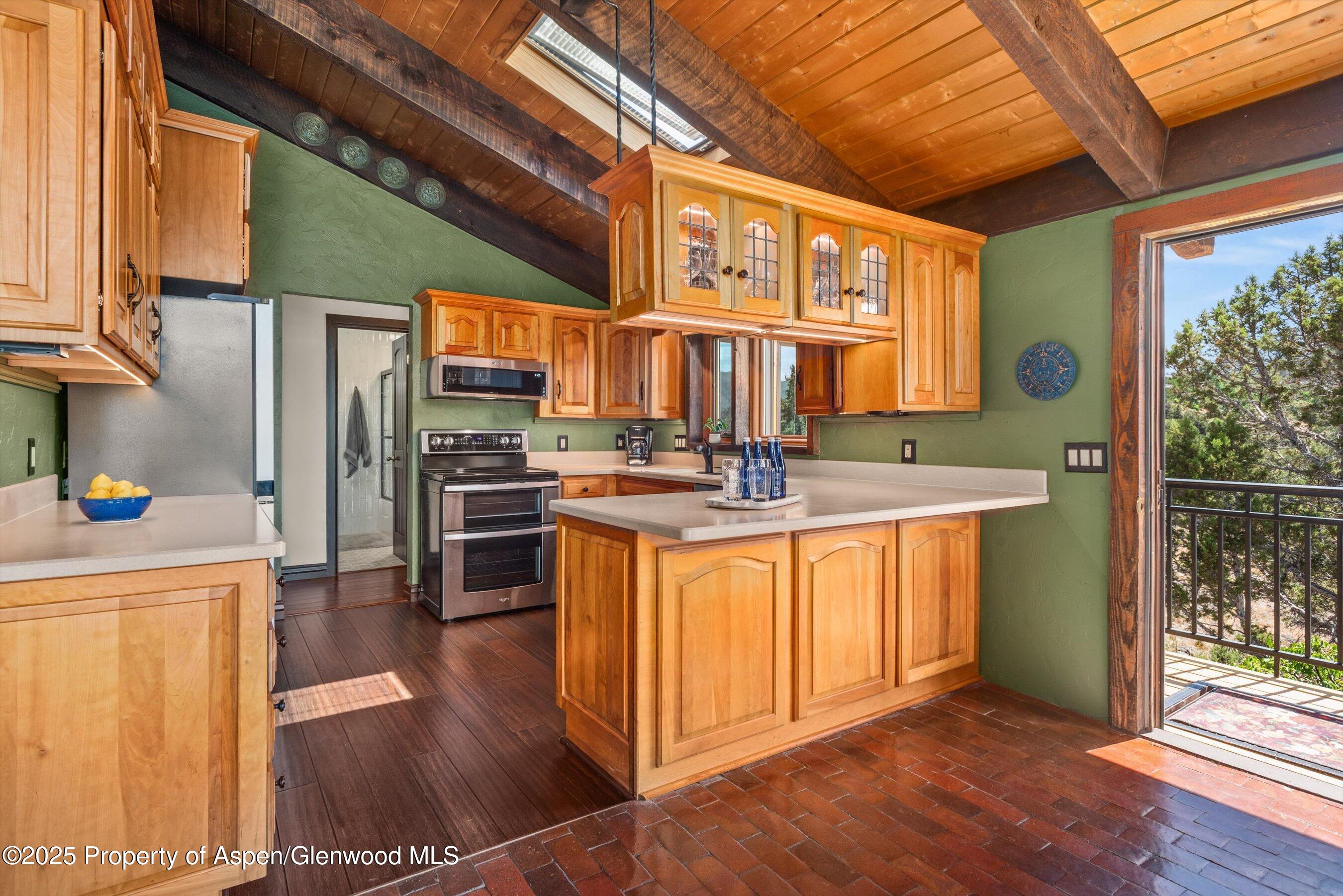 679 Pinon Drive Basalt, CO 81621 - Photo 25 of 52 a kitchen with stainless steel appliances granite countertop a refrigerator a sink dishwasher a stove and a dining table with wooden floor