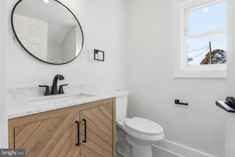a bathroom with a toilet a sink and a mirror