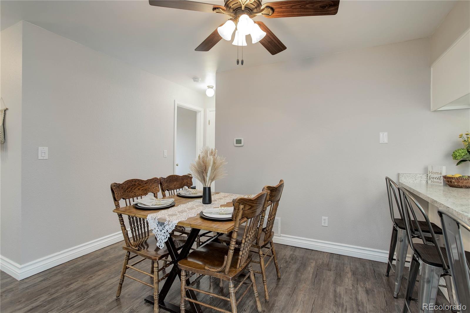 9413 West 89th Circle Westminster, CO 80021 - Photo 12 of 32 a view of a dining room with furniture and wooden floor