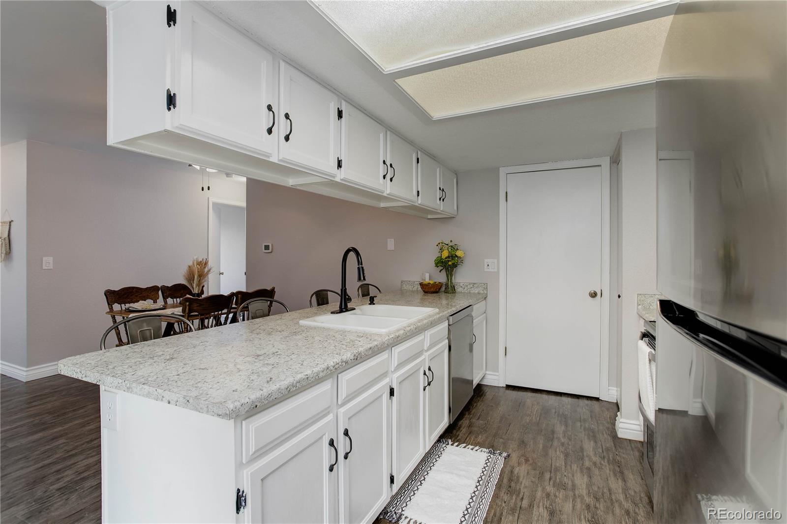9413 West 89th Circle Westminster, CO 80021 - Photo 13 of 32 a kitchen with stainless steel appliances granite countertop a sink stove and refrigerator