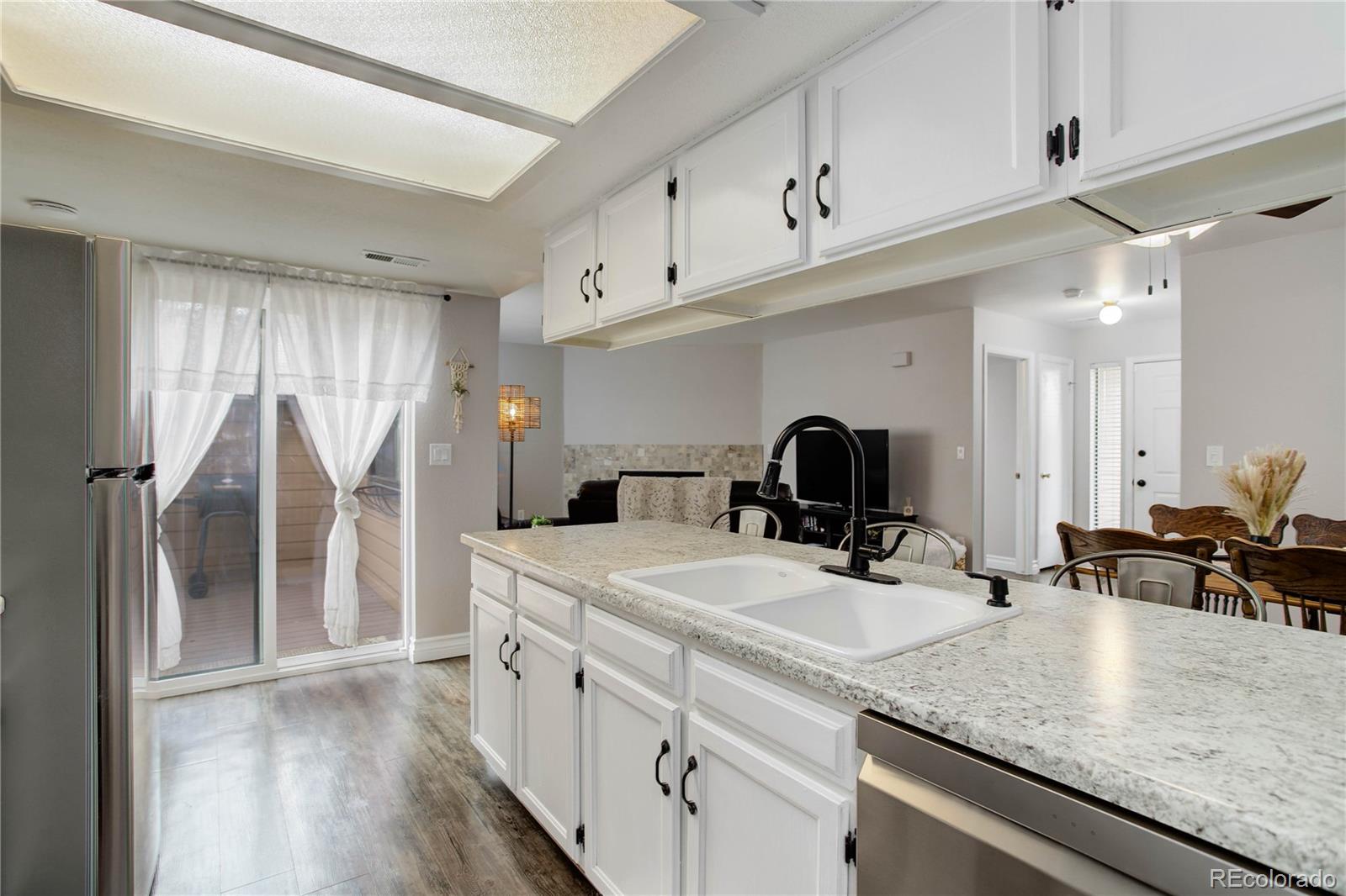9413 West 89th Circle Westminster, CO 80021 - Photo 14 of 32 a kitchen with stainless steel appliances granite countertop a sink refrigerator and cabinets