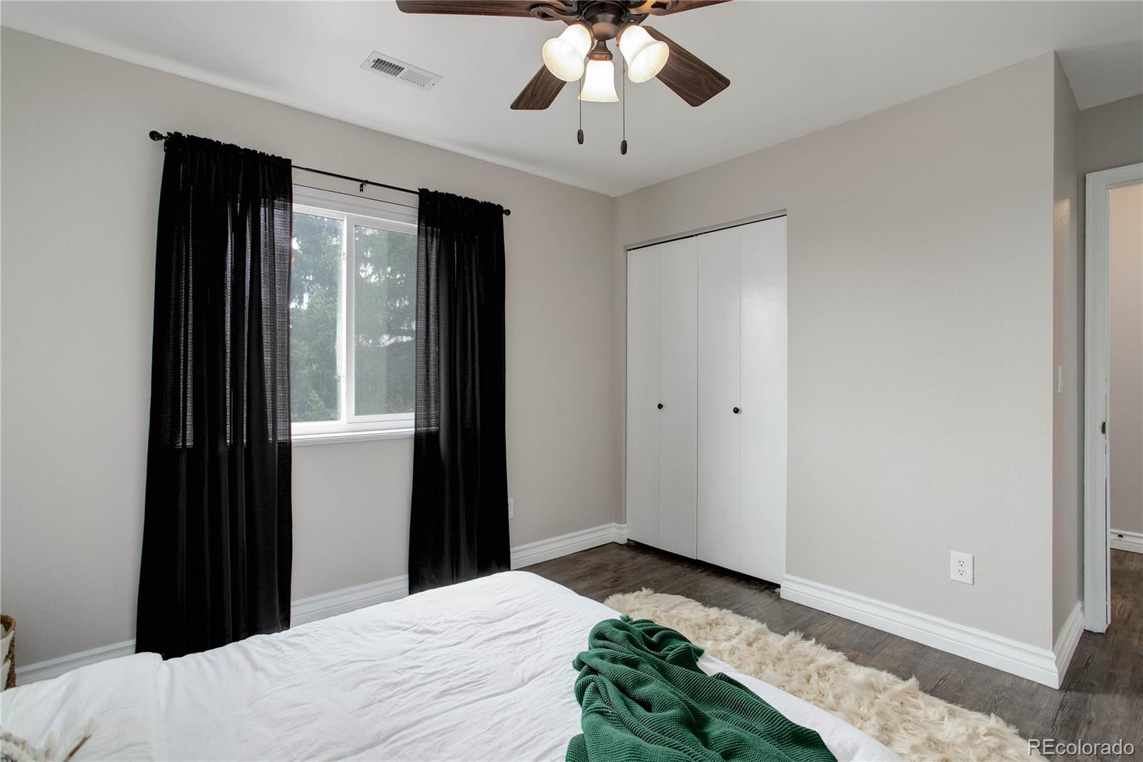 9413 West 89th Circle Westminster, CO 80021 - Photo 23 of 32 a bedroom with a bed and a chandelier