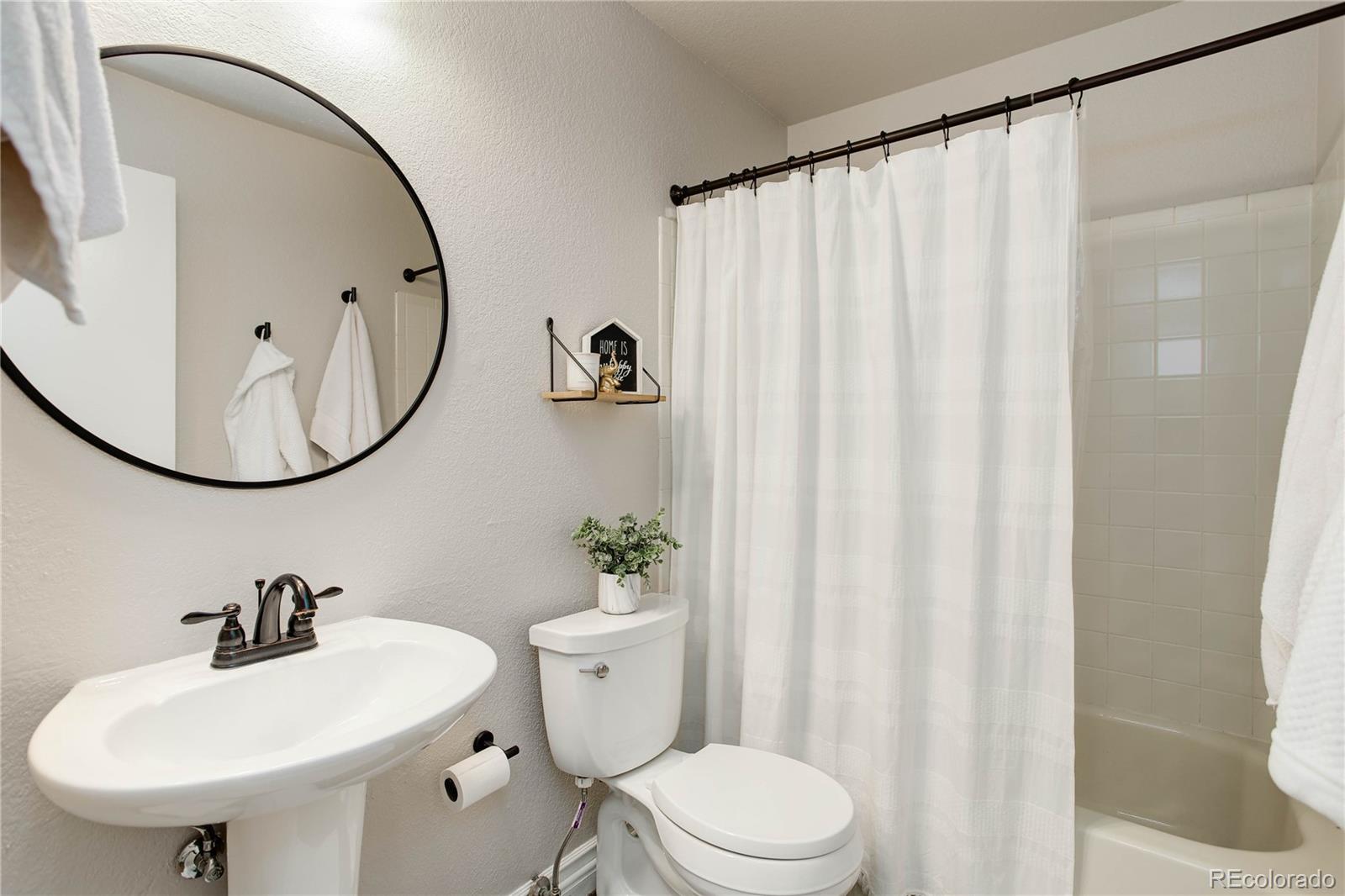 9413 West 89th Circle Westminster, CO 80021 - Photo 26 of 32 a bathroom with a sink a mirror and a toilet