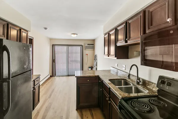 a kitchen that has a sink a refrigerator and cabinets