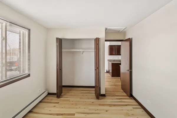 a view of a hallway with wooden floor and a living room