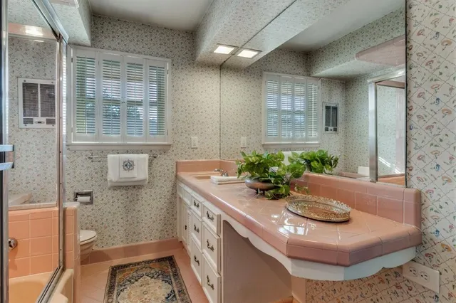 a bathroom with a granite countertop sink a toilet a mirror and shower