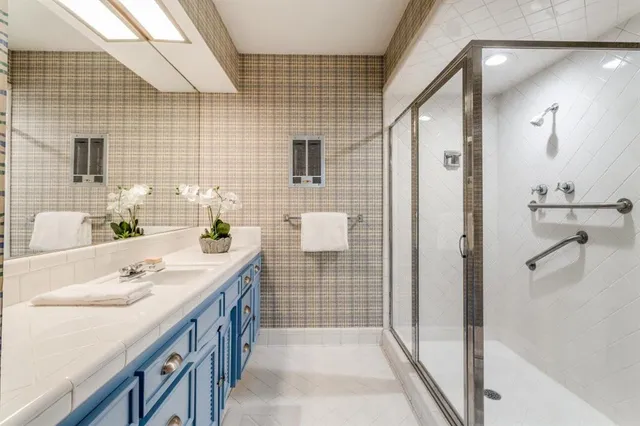 a spacious bathroom with a shower sink and mirror