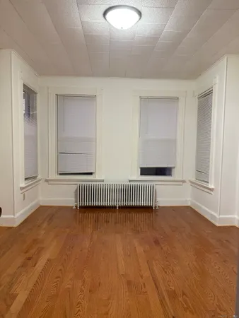 a view of a room with wooden floor and a window