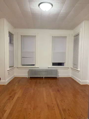 a view of a room with wooden floor and a window