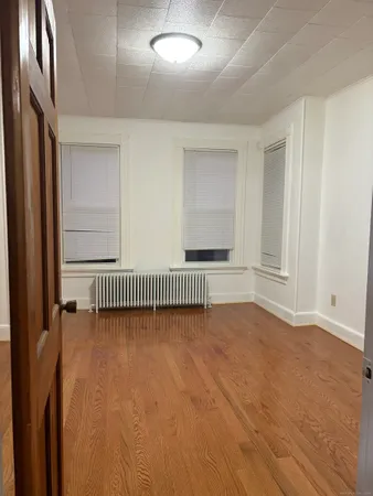 a view of an empty room with a fireplace and a window