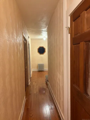 a view of a hallway with wooden floor