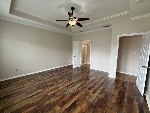 a view of empty room with wooden floor