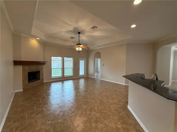 a view of an empty room with a fireplace and a window