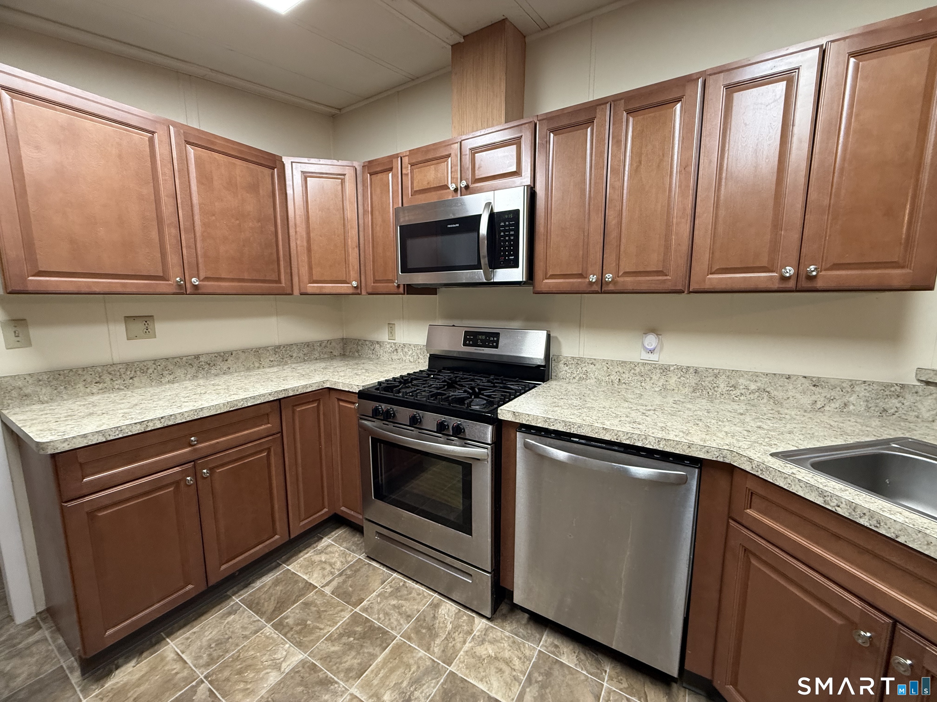 183 Whalehead Road Ledyard, CT 06335 - Photo 9 of 24 a kitchen with granite countertop wood cabinets stainless steel appliances and a sink