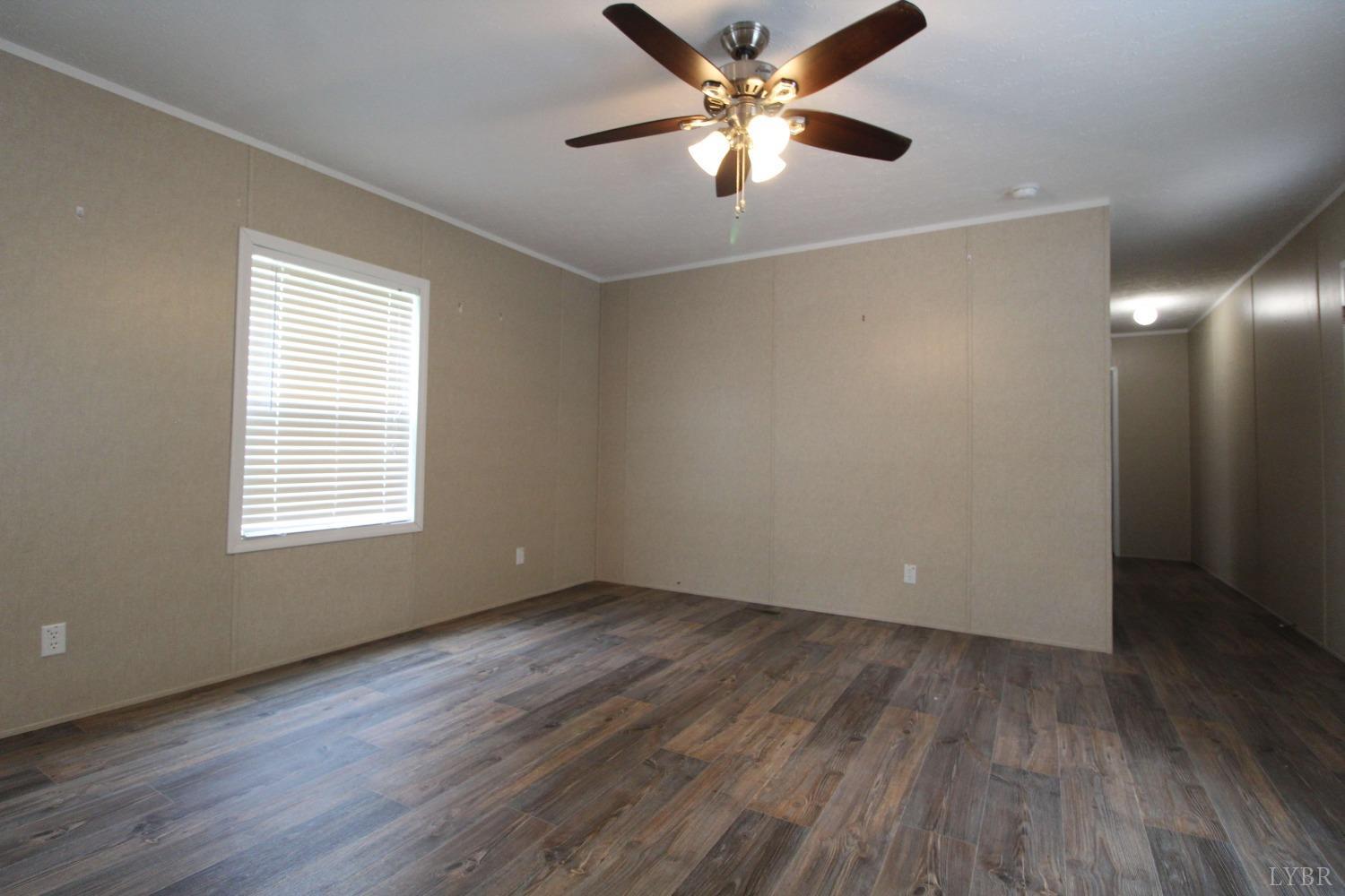 1104 Holiday Lake Road Pamplin, VA 23958 - Photo 9 of 19 a view of an empty room with wooden floor and a window