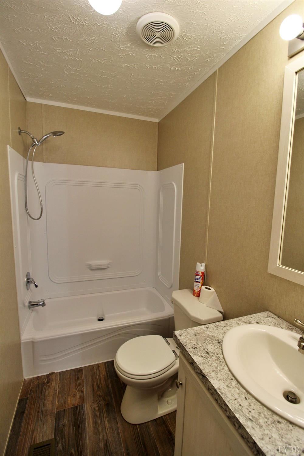 1104 Holiday Lake Road Pamplin, VA 23958 - Photo 10 of 19 a bathroom with a granite countertop sink toilet and shower