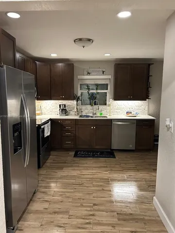 a large kitchen with kitchen island a sink stainless steel appliances and cabinets