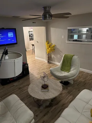 a living room with furniture and view of kitchen