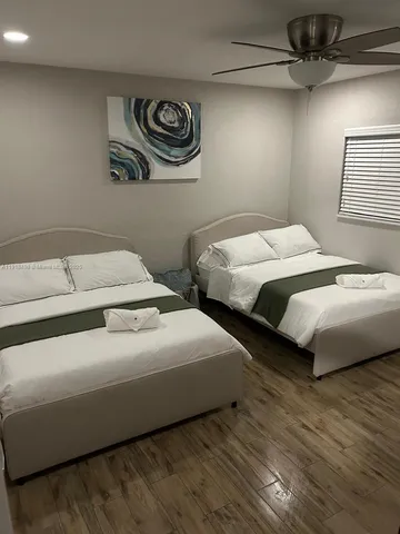 a bedroom with two beds and painting on the wall