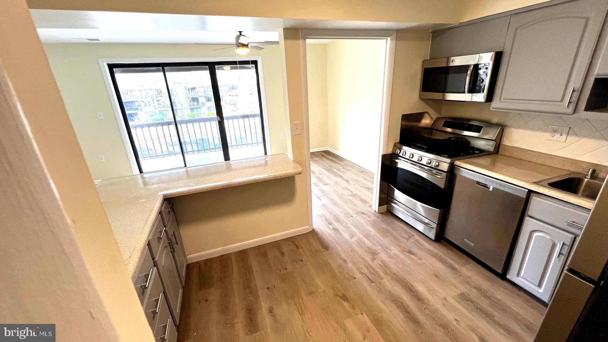 10073 Windstream Drive, Unit 5 Columbia, MD 21044 - Photo 15 of 17 a kitchen with stainless steel appliances a refrigerator microwave and wooden floor