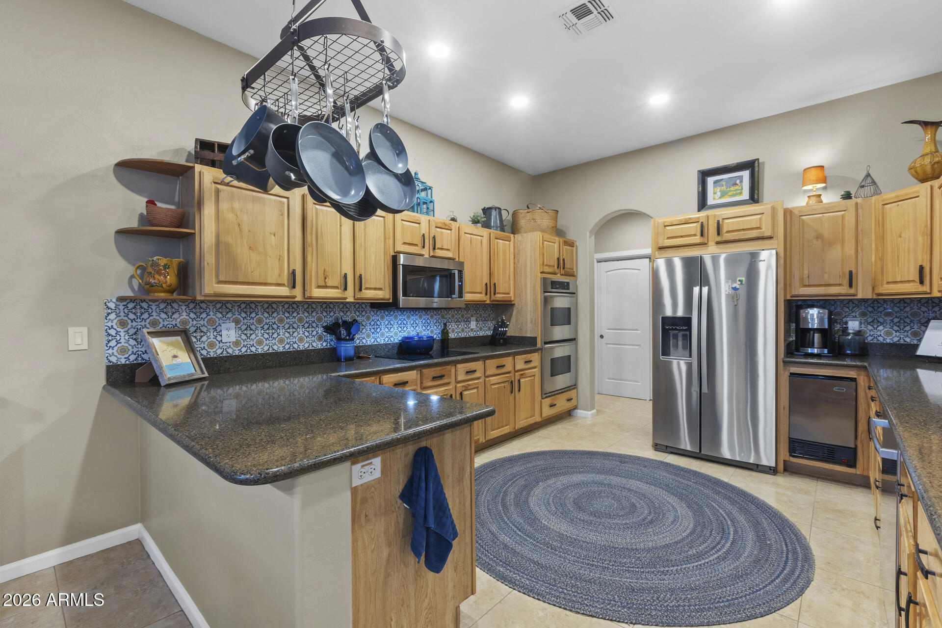 14526 West Jomax Road Surprise, AZ 85387 - Photo 16 of 57 a kitchen with stainless steel appliances granite countertop a sink a refrigerator and a stove top oven