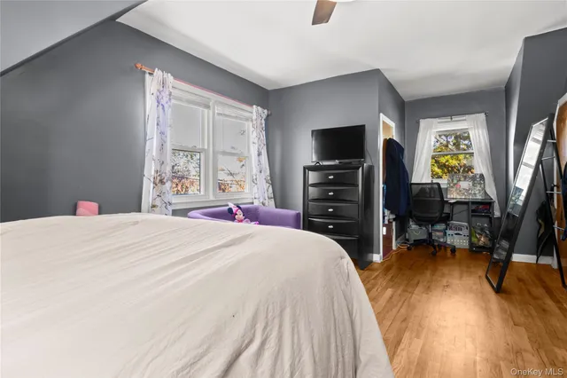 a bedroom with a bed and a flat tv screen on dresser