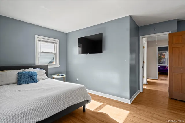 a bedroom with a bed and wooden floor