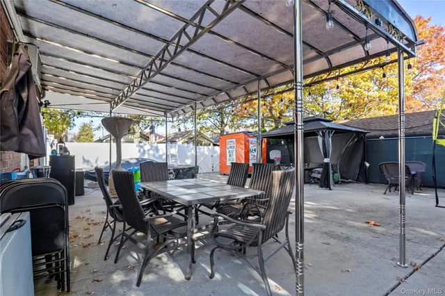 a backyard of a house with barbeque oven table and chairs